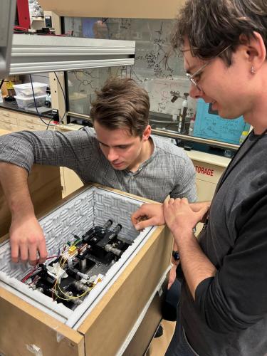Groman and Kudelin working on the integrated photonic microwave oscillator in Diddams’ lab. Courtesy: University of Colorado Boulder